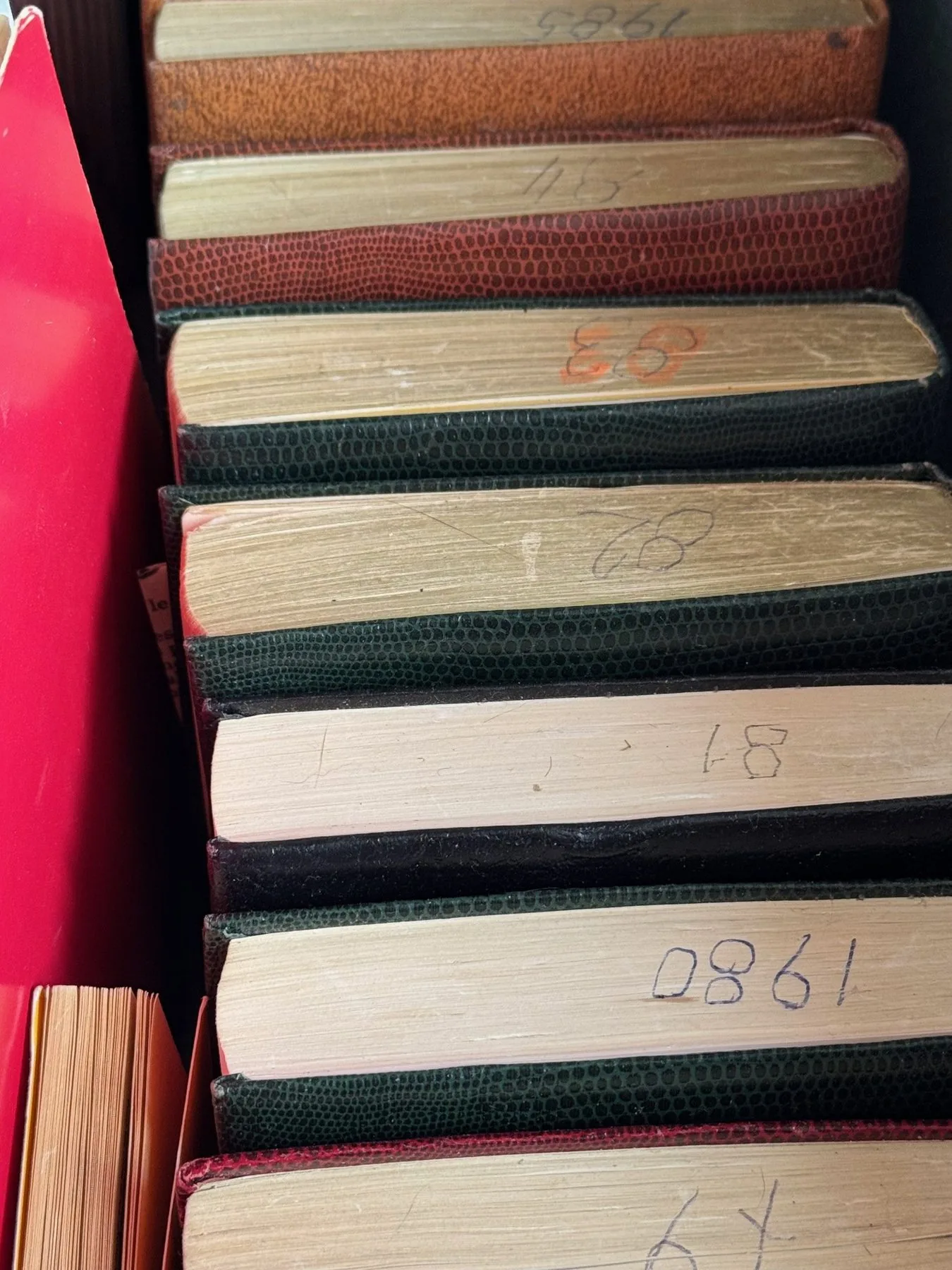 Pile de carnets manuscrits aux tranches numérotées à la main.