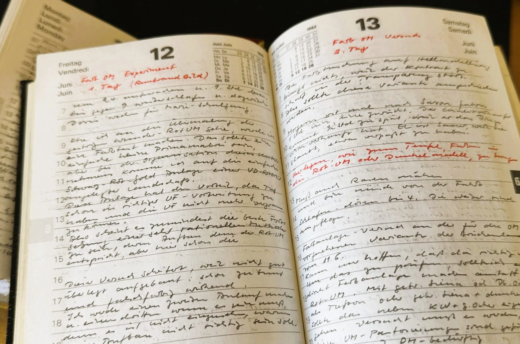 Carnet ouvert sur deux pages manuscrites annotées au crayon rouge.